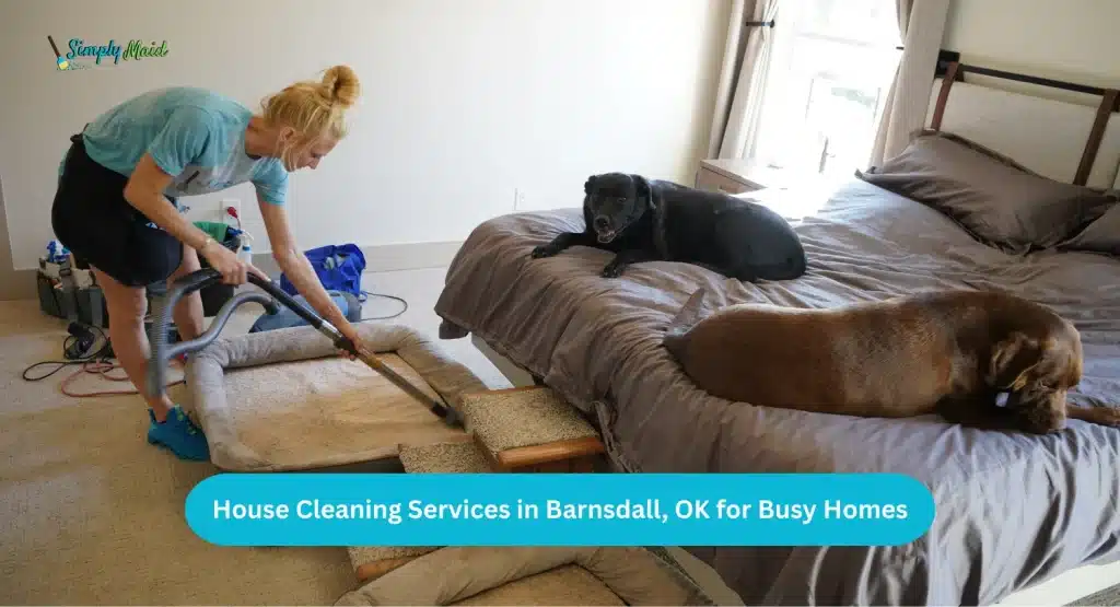 Woman vacuuming bedroom with two dogs on bed, showcasing house cleaning services in Barnsdall, OK for busy homes.