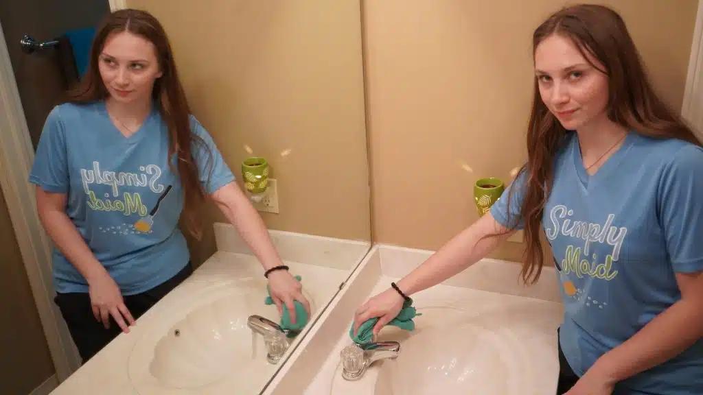Two Simply Maid Sparkle Technicians cleaning double bathroom sinks
