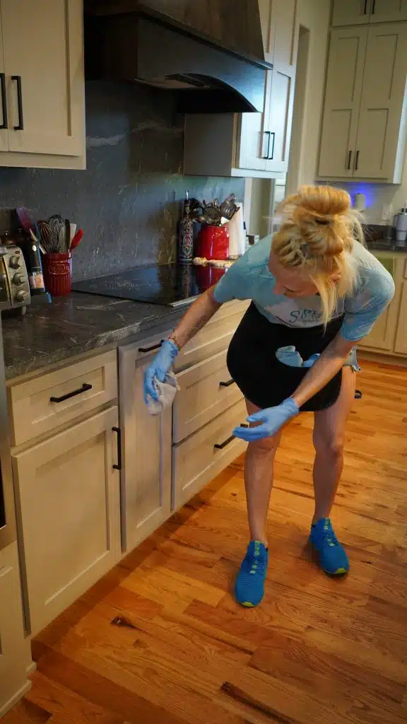 Simply Maid Sparkle Technician cleaning kitchen cabinets