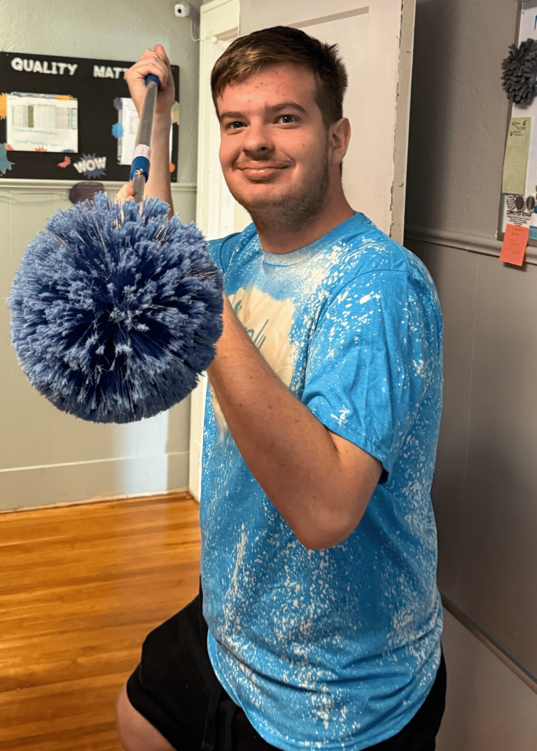Simply Maid Sparkle Technician holding a large cleaning duster.